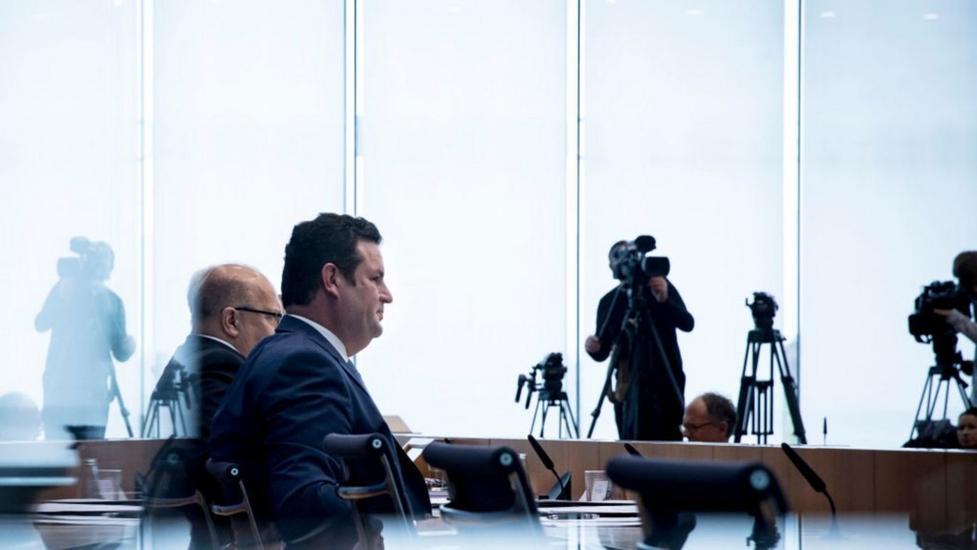 Zwei Politiker vor Kameras in einem Raum.