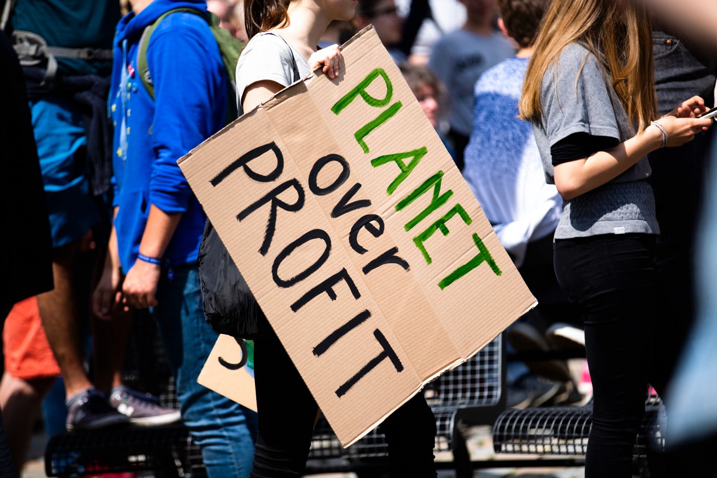 Eine Nahaufnahme eines Plakats auf einer Demonstration, mit der Aufschrift - Planet over Profit.
